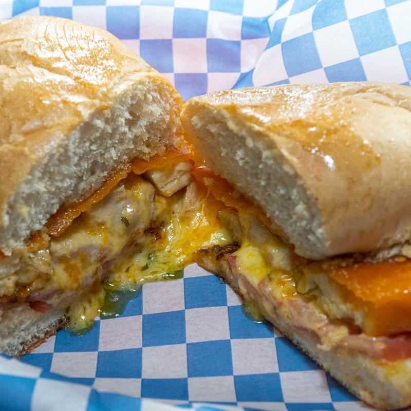 New York strip steak sandwich with grilled onions, tomatoes, and cheese